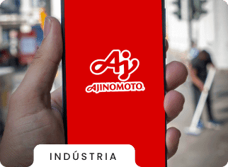 imagem de uma mão segurando um celular com a logo da Ajinomoto no fundo de tela