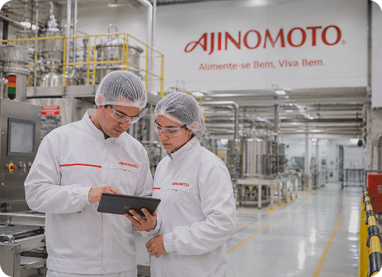 imagem gerada por IA de funcionários mexendo em um tablet dentro de uma fábrica Ajinomoto